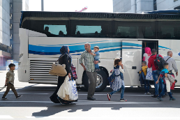 Una famiglia siriana con tre bambini sale su un autobus all’aeroporto di Zurigo insieme ad altri rifugiati reinsediati.